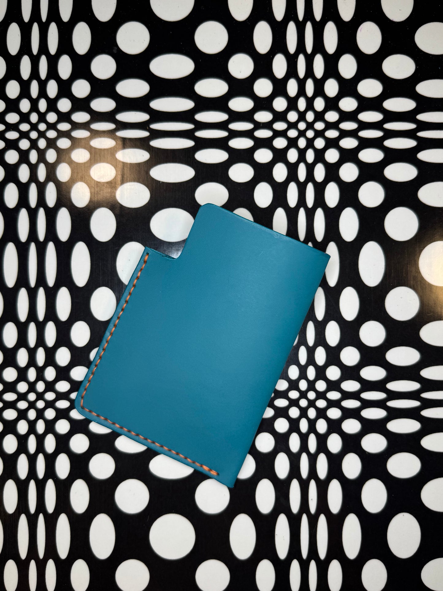 Blue leather passport sleeve on polka dot background 